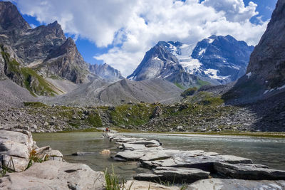 Scenic view of lake by mountains against sky