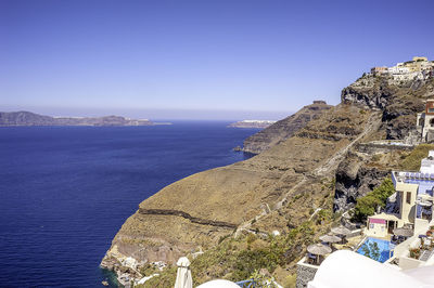 Aerial view of townscape by sea against clear blue sky