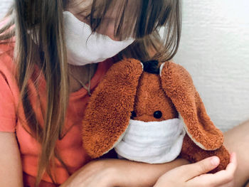 Rear view of girl sitting with toy