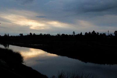 Scenic view of lake against sky at sunset