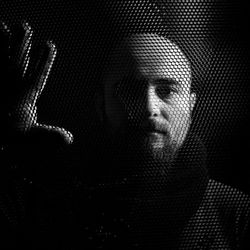 Portrait of man seen through fence in darkroom