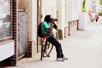 Full length of man sitting on bicycle in city