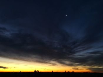 Silhouette of electricity pylon at sunset