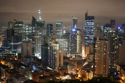 High angle view of illuminated buildings against sky at night