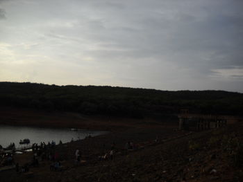 Group of people on beach against sky