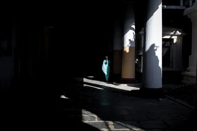 Man walking in illuminated corridor of building