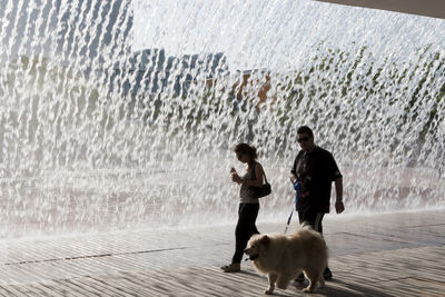 People with dog in rain