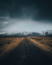 Road leading towards mountain against sky