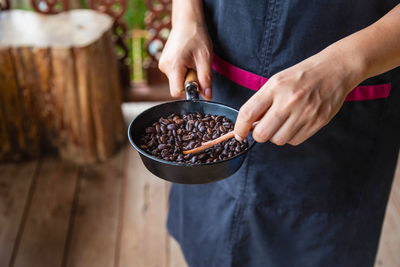 Midsection of man holding coffee beans