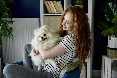 Young woman with dog sitting at home
