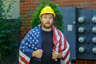 Portrait of man standing against yellow wall