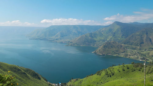 Scenic view of sea and mountains against sky