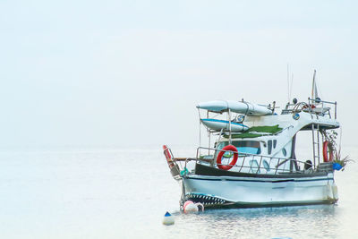 Boat moored on beach against clear sky
