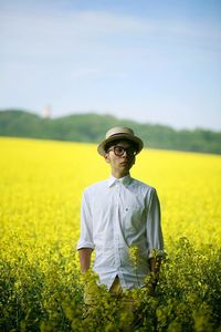 Full length of woman standing on field against sky