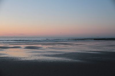 Scenic view of sea against clear sky at sunset