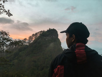 Rear view of man looking at mountain against sky