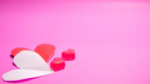 Close-up of heart shape over pink background