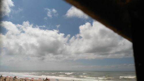 Scenic view of beach against cloudy sky