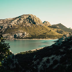 Scenic view of lake and mountains against clear sky