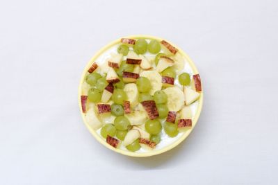 Close-up of fruits in bowl over white background