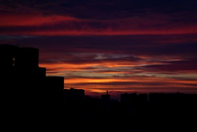 Silhouette cityscape against sky during sunset