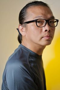 Portrait of man wearing eyeglasses against black background