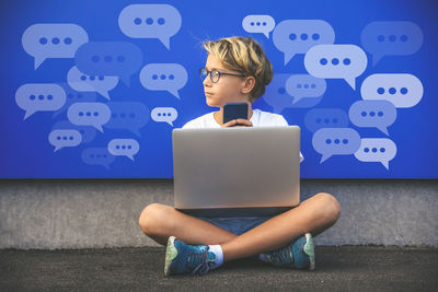 Boy using smartphone typing, chatting conversation concept. chat box icons. social media maketing.
