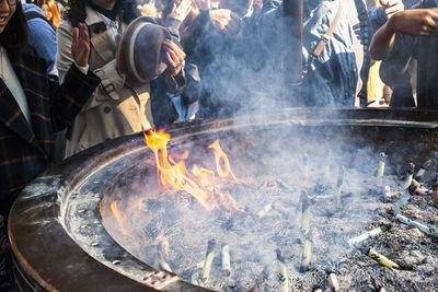 People praying by fire pit