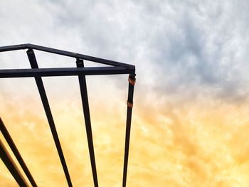 Low angle view of metallic structure against sky during sunset