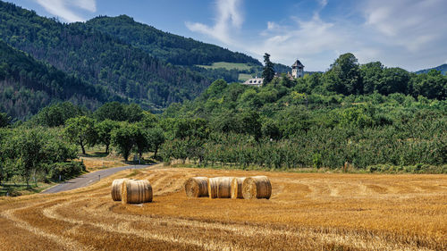 Hay bales on field against sky