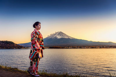 Woman wearing traditional clothes while standing by sea