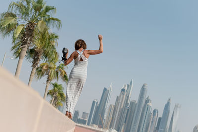 Woman walking on wall in city