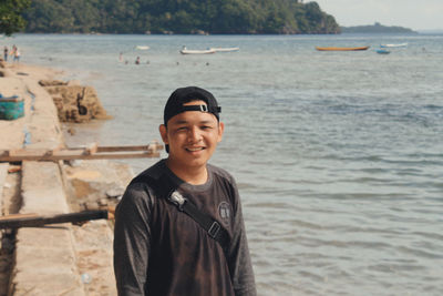 Portrait of smiling young man standing in sea