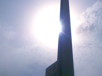 Low angle view of sun shining through clouds