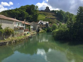 Scenic view of lake by buildings against sky