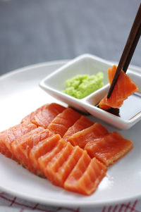 Dipping salmon into soy sauce