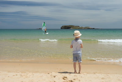 Full length of boys on beach against sky