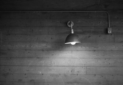 Low angle view of illuminated lamp hanging on wall