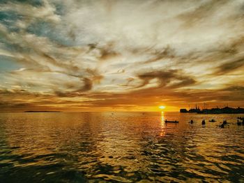 Scenic view of sea against dramatic sky during sunset