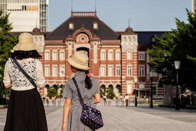 Rear view of people walking on street in city