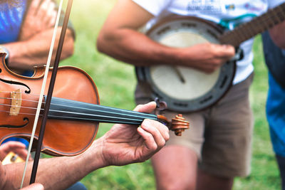 Midsection of people playing musical instruments