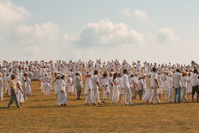 Group of people on field against sky