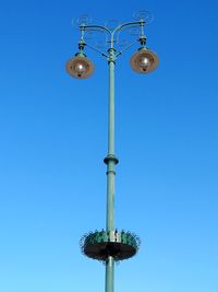 Low angle view of street light against blue sky