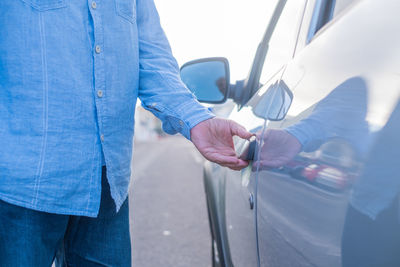 Midsection of man cleaning car