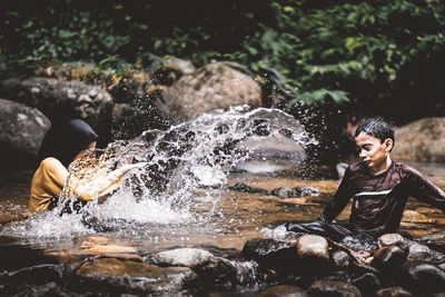 Cheerful siblings playing in river