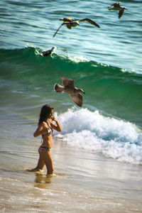 Full length of girl standing in sea