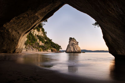 Rock formations on sea shore against sky