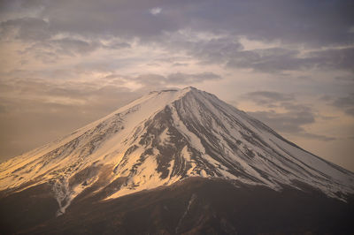 Scenic view of snowcapped mountain against sky during sunset