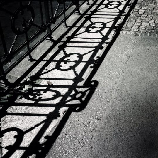 bicycle, transportation, shadow, mode of transport, land vehicle, sunlight, street, high angle view, parking, metal, stationary, railing, sidewalk, day, the way forward, road, no people, outdoors, absence, footpath