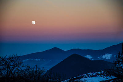 Scenic view of snowcapped mountains against sky at dusk